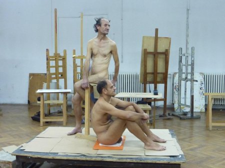 A naked man poses an artist